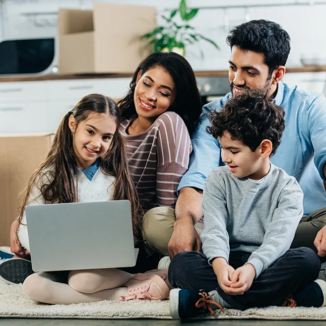Smiling young Latino family looking at laptop computer