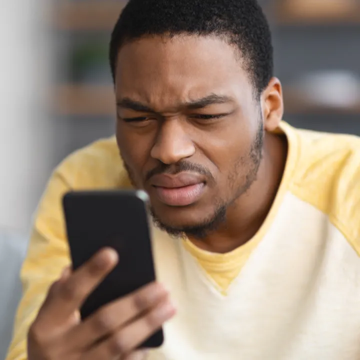 A man struggles to read his phone due to diabetes related eye complications