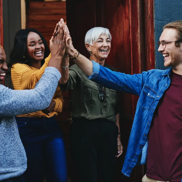 Group of people giving each other high-fives.