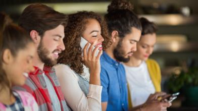 Group of young adults looking at smart phones