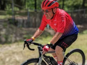 Don riding a bicycle on a road