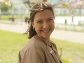a smiling girl with brown hair on a spring day