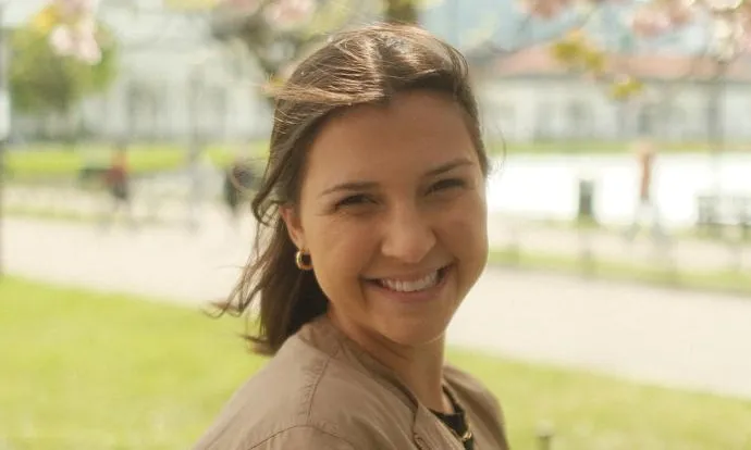 a smiling girl with brown hair on a spring day