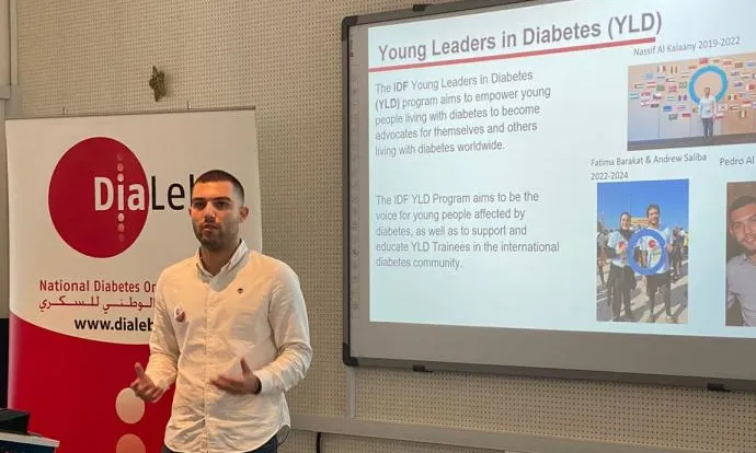 A man presenting in front of a screen about young leaders in diabetes.