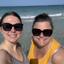 Close up photo of Leora and a friend on a beach