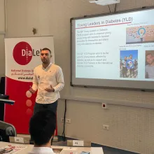 A man presenting in front of a screen about young leaders in diabetes.