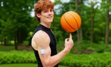 Young man spinning a basketball on his finger with an insulin pump on his arm