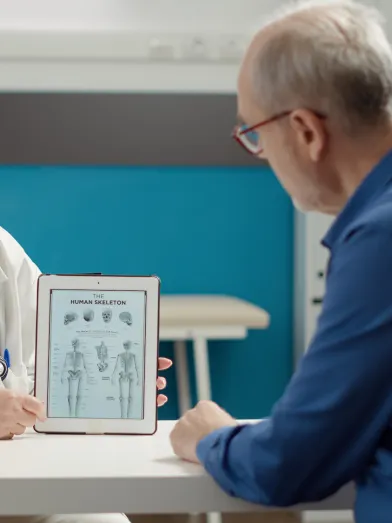 Nurse practitioner showing tablet computer to patient with diagnosis information