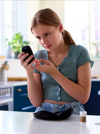Young girl checking her blood glucose with meter