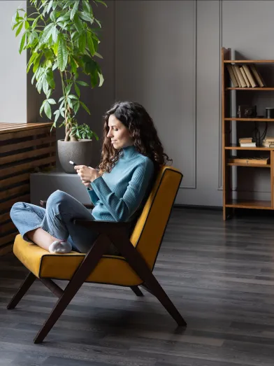 Woman sitting in chair shopping on her smartphone