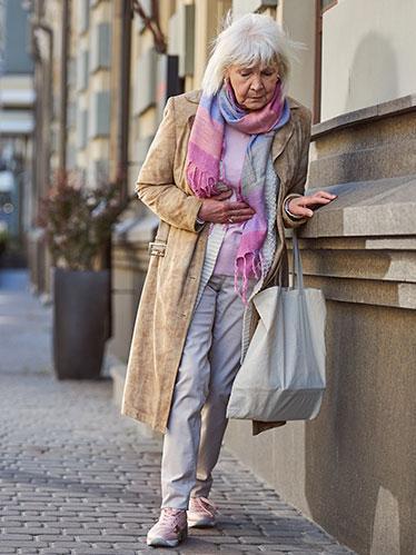senior-woman-leaning-wall