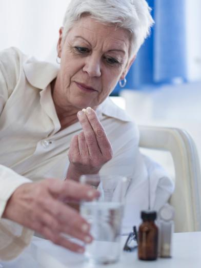 Senior woman in bed taking medication