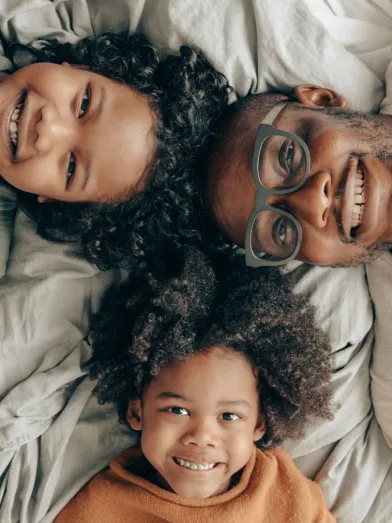 A dad wearing glasses plays with his 2 kids as a reminder as to why he wants to protect his vision from diabetes