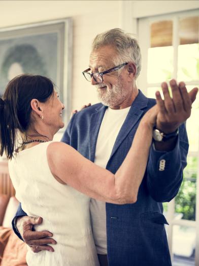 Mature couple dancing together indoors